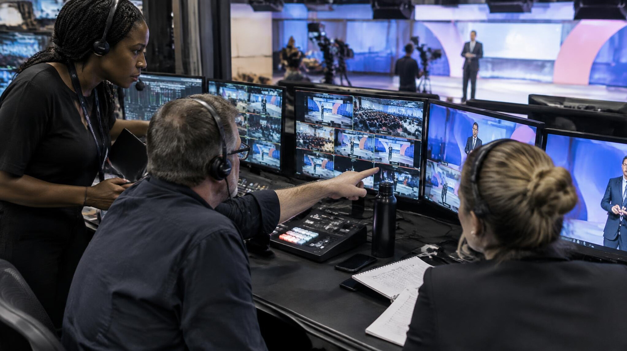 Director and crew coordinating a live television show from a gallery desk