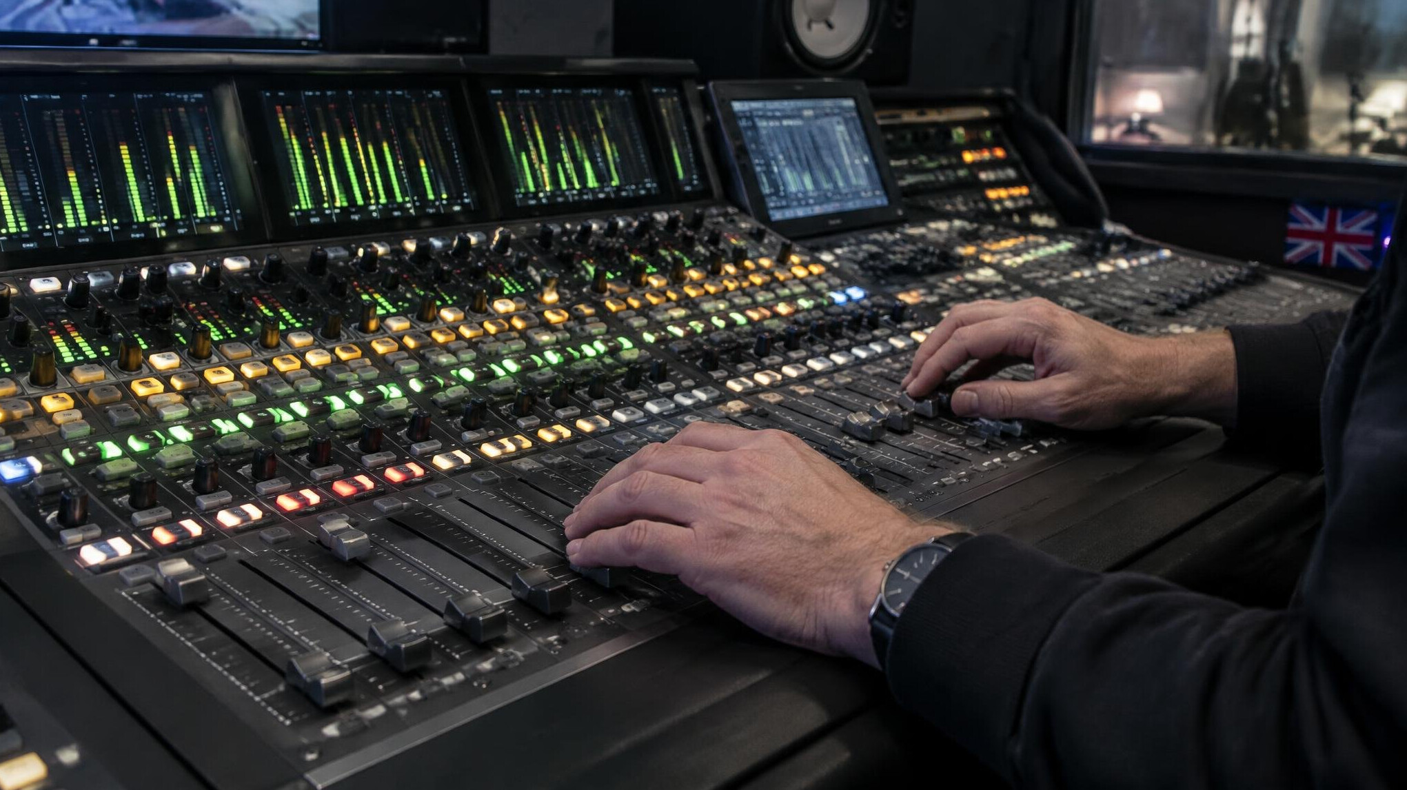 Sound engineer working at a broadcast audio mixing console